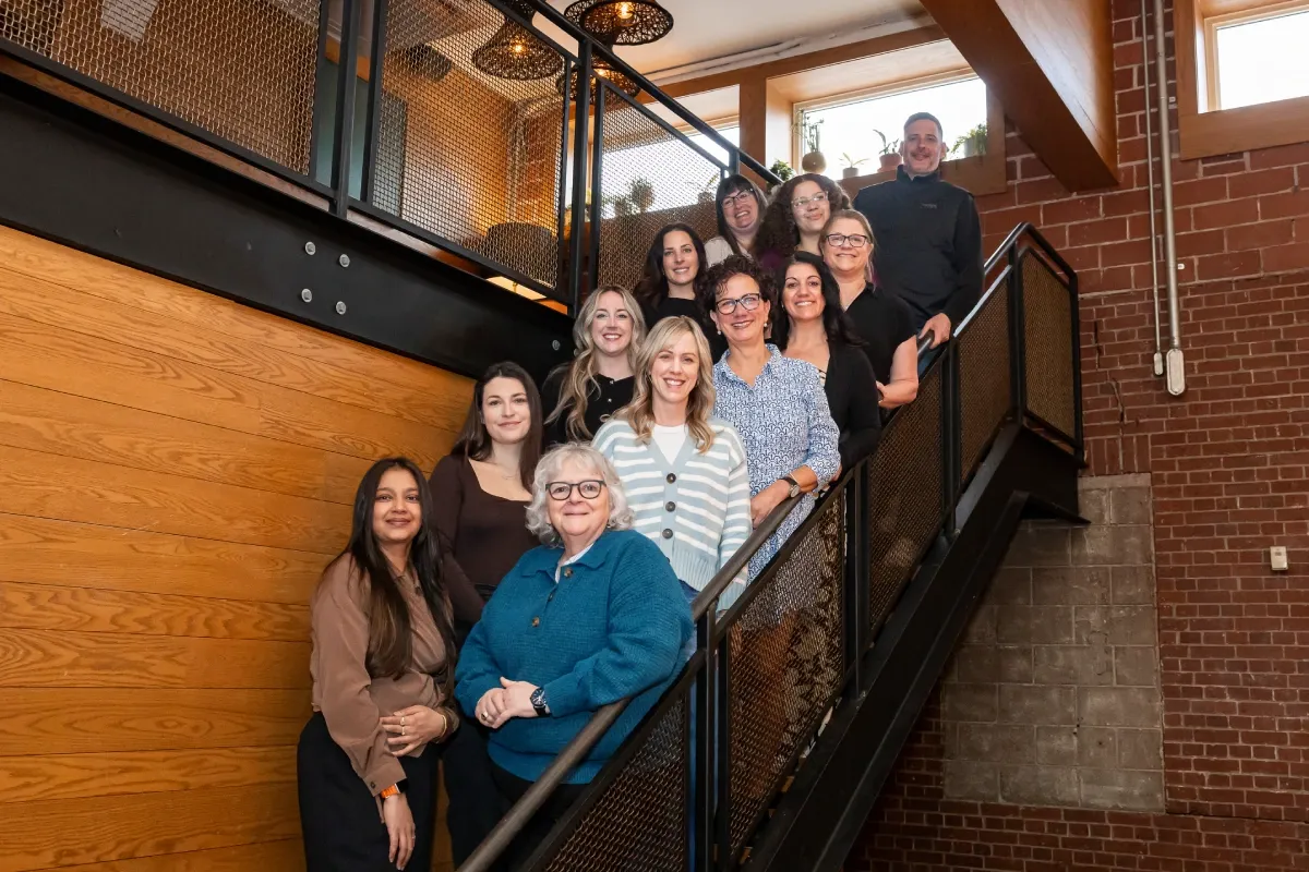 A group of people pose for a photo on a staircase.